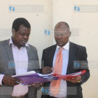 Activist Okiya Omtatah (left) consults with lawyer Robert Asembo for Bado Mapambano Trust outside Milimani Law Courts