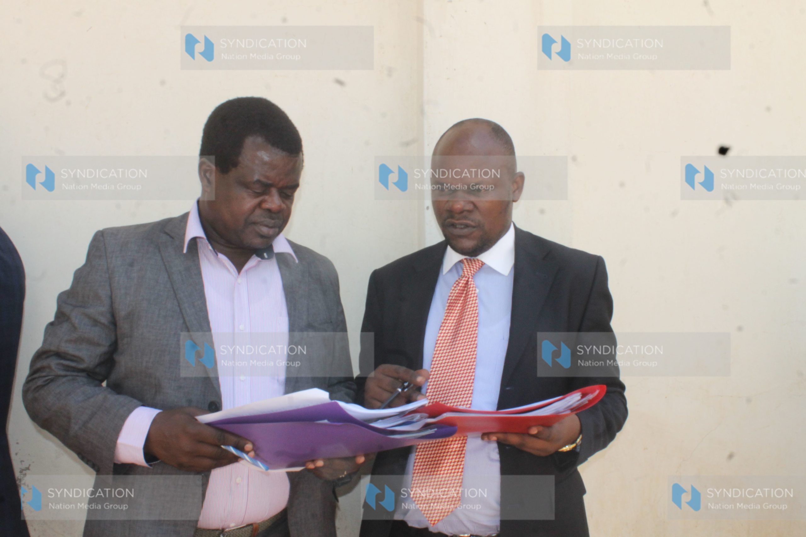 Activist Okiya Omtatah (left) consults with lawyer Robert Asembo for Bado Mapambano Trust outside Milimani Law Courts