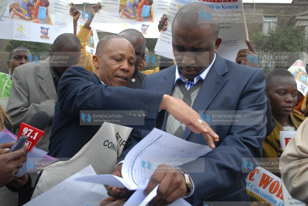 KUDHEIHA Secretary General Albert Njeru (left) presents a document to Igembe North MP Mithika Linturi (right)