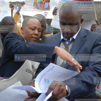 KUDHEIHA Secretary General Albert Njeru (left) presents a document to Igembe North MP Mithika Linturi (right)