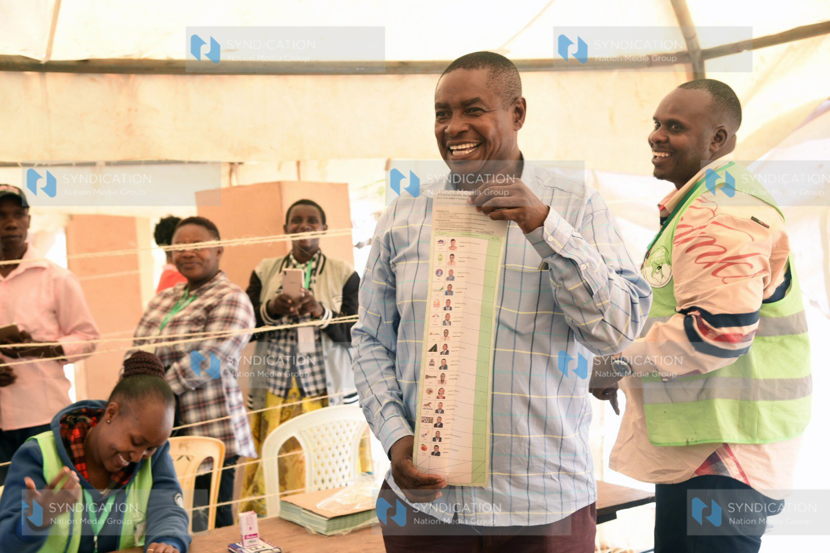 Julius Mawathe displays a ballot paper before casting his vote