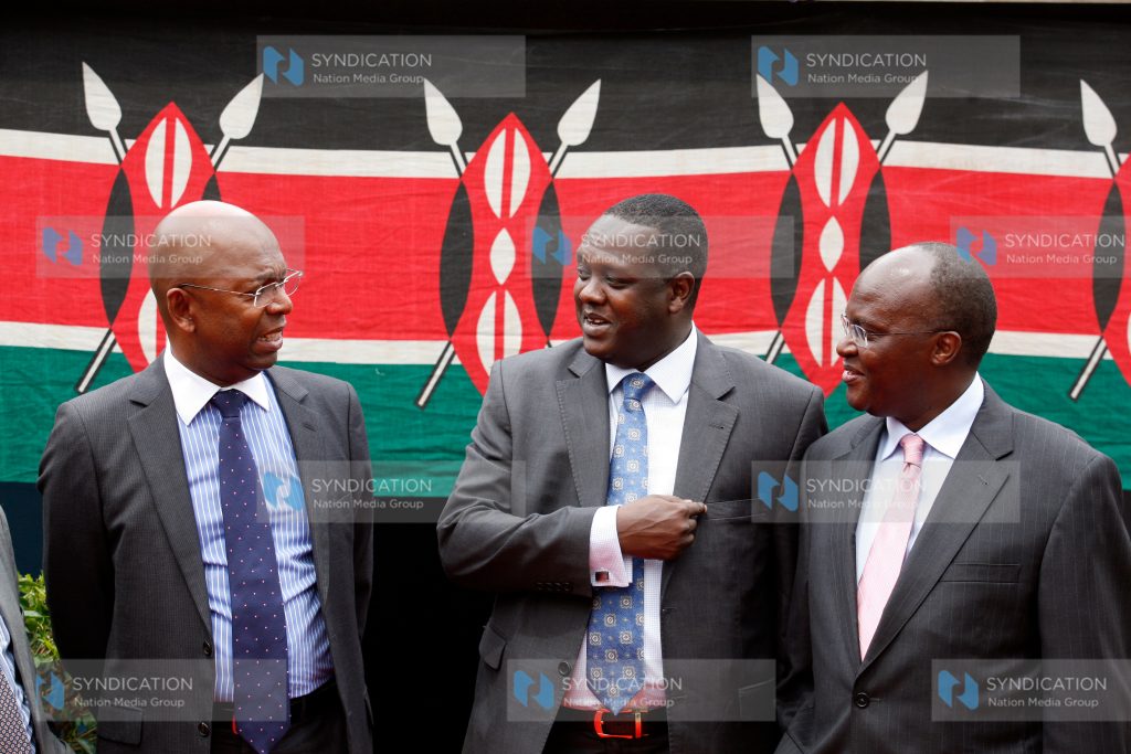 Safaricom Chief Executive Officer Bob Collymore chats with Sports and Culture Cabinet Secretary Hassan Wario and his Health colleague James Macharia