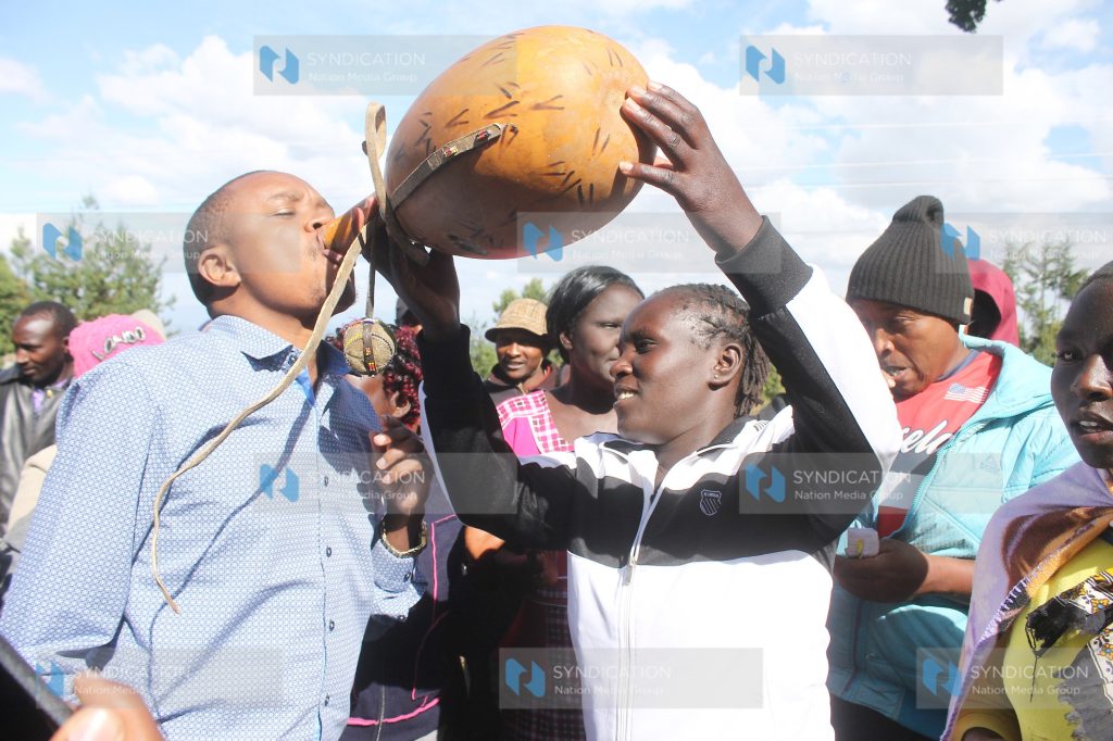 Kipsigis women serve Molo MP Kuria Kimani with mursik