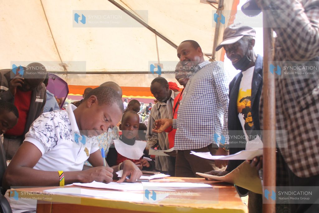 Molo MP Kuria Kimani assists parents in filling the students’ bursary forms