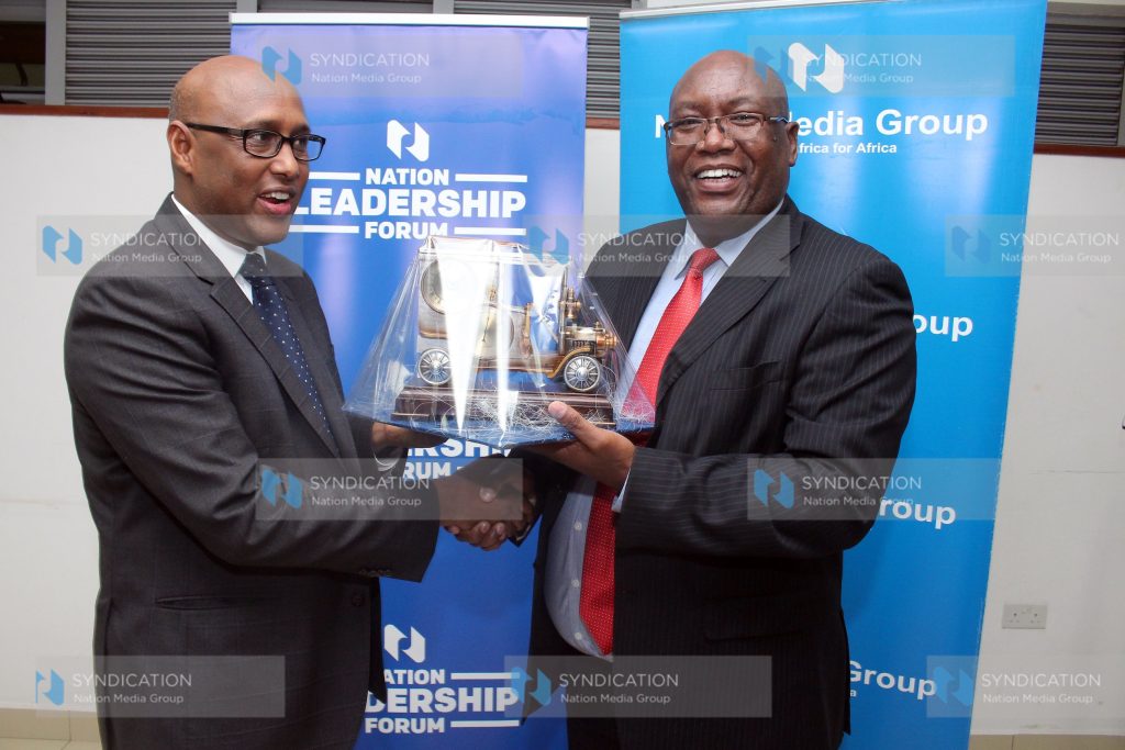 Nation Media Group acting CEO Stephen Gitagama presents a gift to Cabinet Secretary Ministry of Industry, Trade and Cooperatives Adan Mohamed