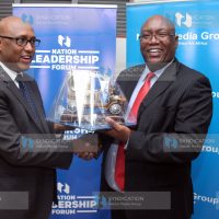 Nation Media Group acting CEO Stephen Gitagama presents a gift to Cabinet Secretary Ministry of Industry, Trade and Cooperatives Adan Mohamed