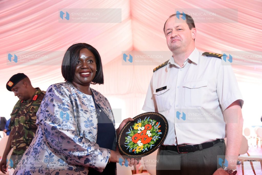 Defence Cabinet Secretary Raychelle Omamo receiving a gift from Embassy of Ukraine Defence Attache Colonel Andrii Kuzora
