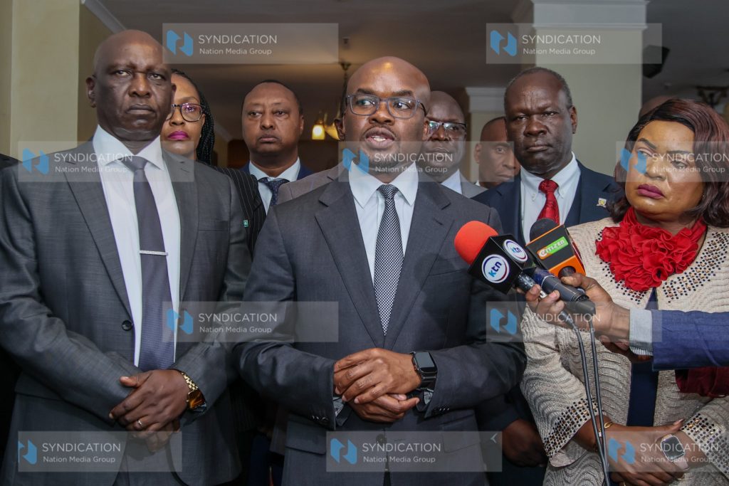 Principal Secretary for the State Department for Internal Security and National Administration, Dr Raymond Omollo (centre), addresses the media