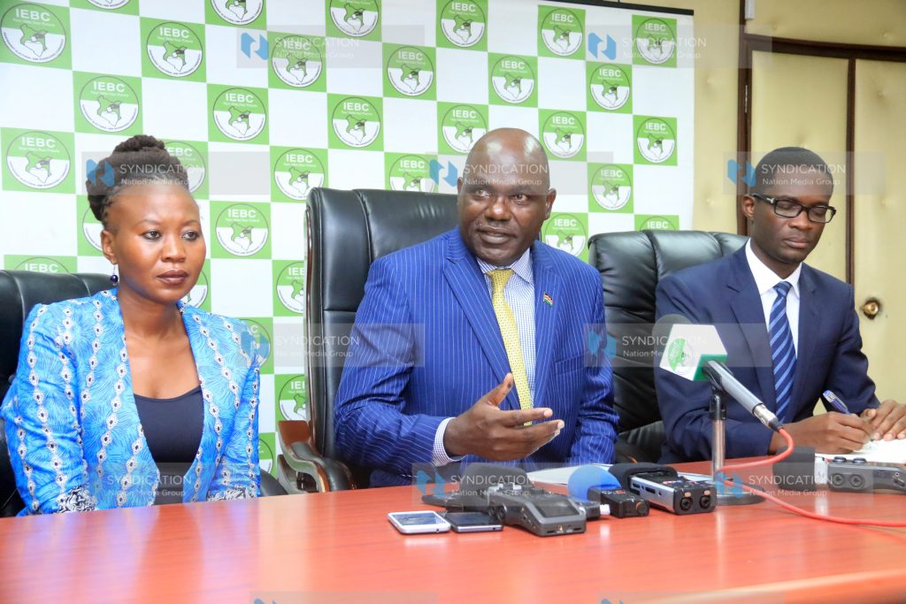 (IEBC) Chairman Wafula Chebukati (center), CEO Ezra Chiloba (right) and Commissioner Roselyne Akombe (left) confer during press conference