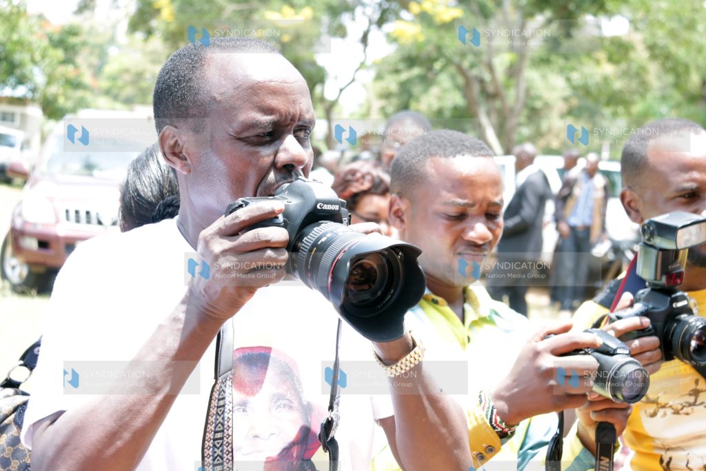 Embu Senator Lenny Kivuti takes photographs during the requiem Mass for his 117-year-old grandmother