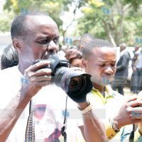 Embu Senator Lenny Kivuti takes photographs during the requiem Mass for his 117-year-old grandmother