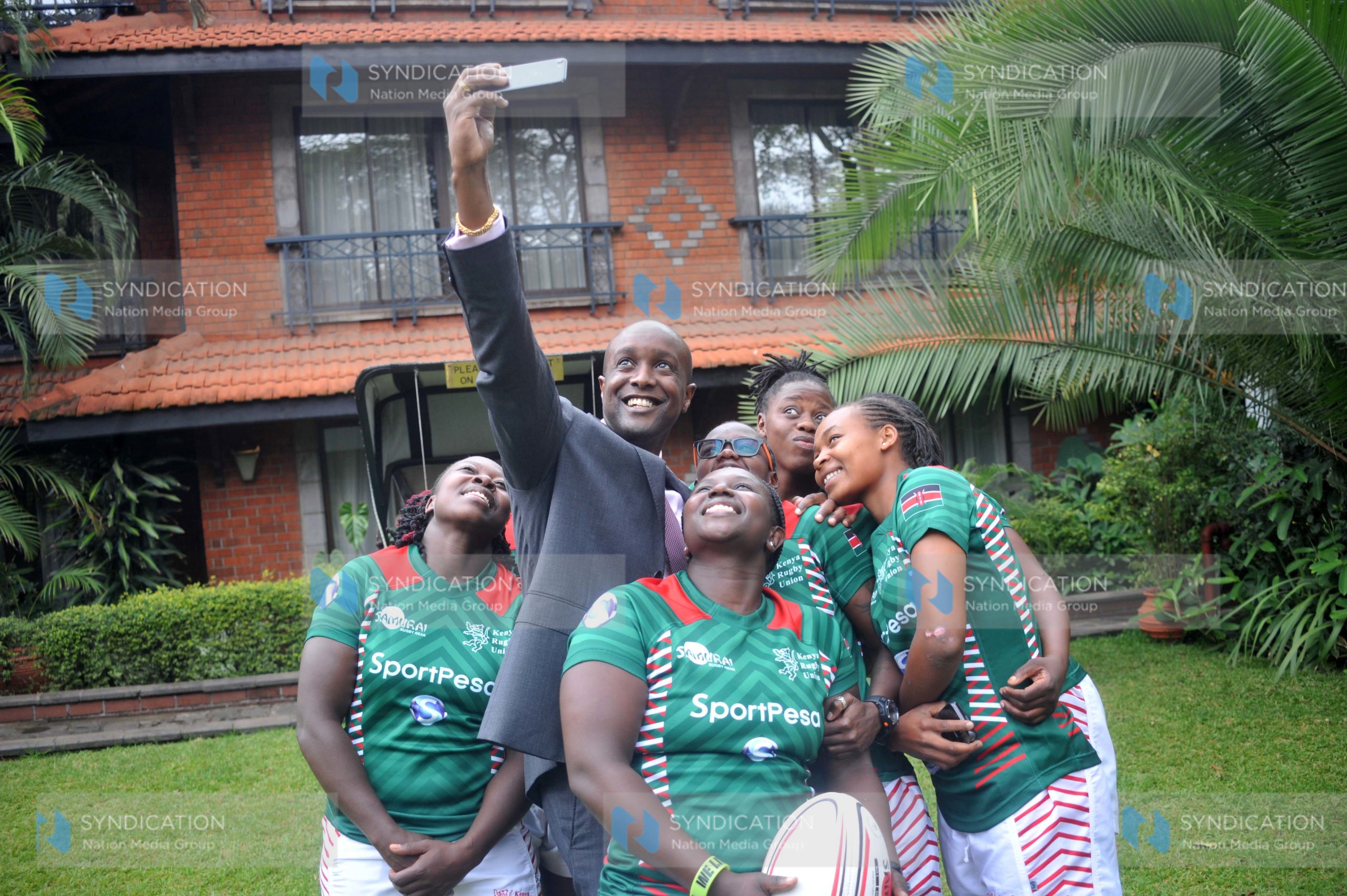 Sportpesa Chief Executive Officer Ronald Karauri with Ladies, National seven aside Rugby Teams players
