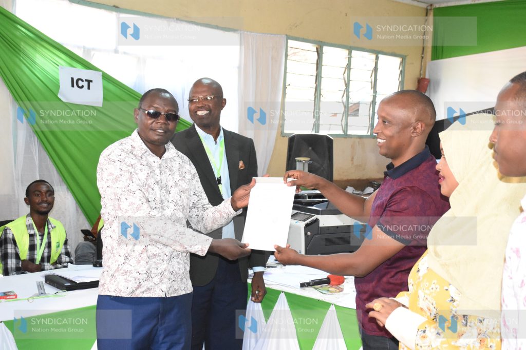 Isiolo Governor-elect Abdi Ibrahim Hassan Guyo (R) with his deputy James Lowasa display a certificate