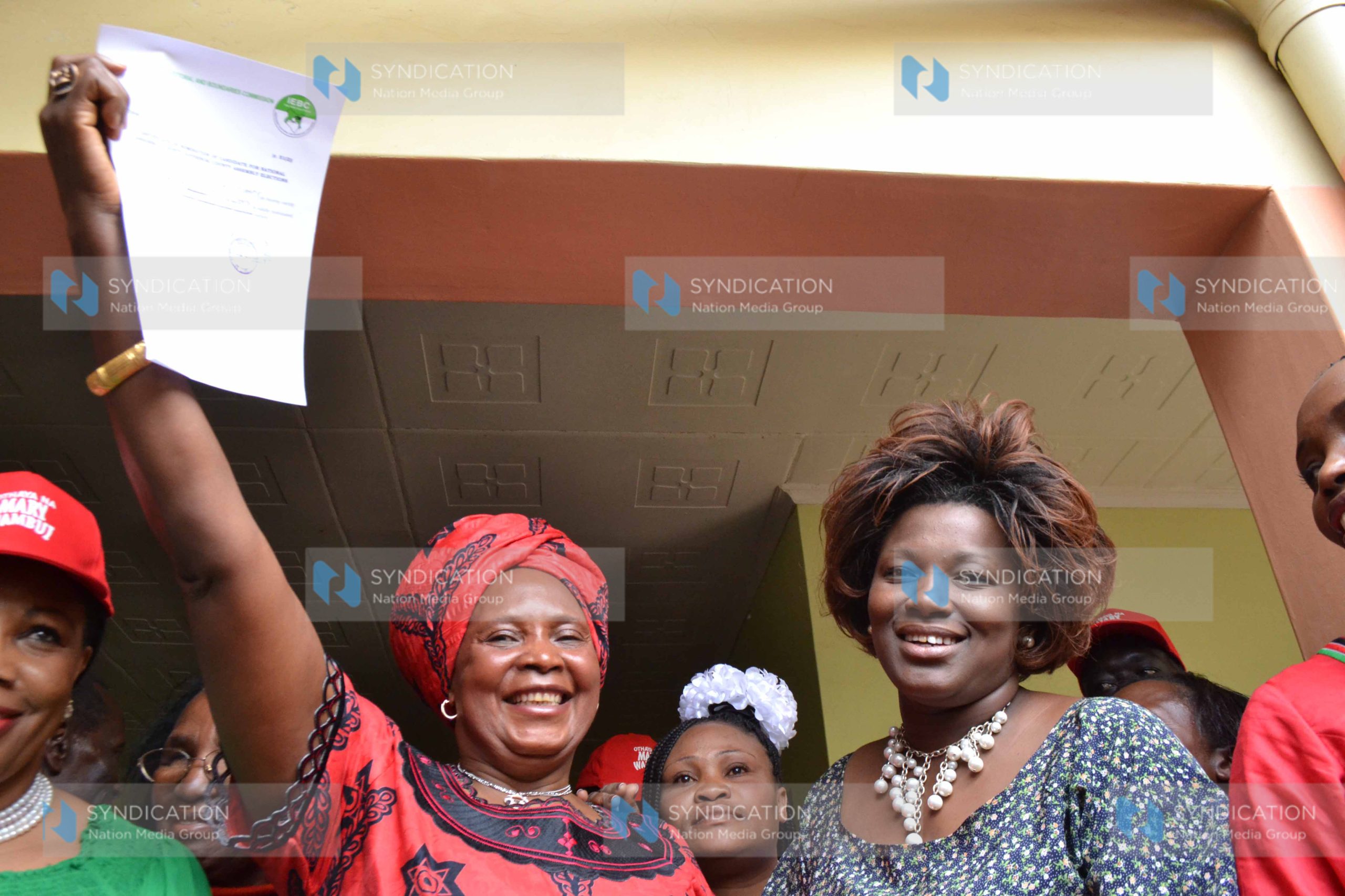 Mary Wambui, left, displays a copy of IEBC certificate